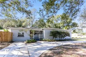 St. Petersburg house for rent - a small white house with a driveway and trees