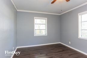 St. Petersburg house for rent - a bedroom with grey walls and wood floors and a ceiling fan