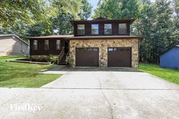 Atlanta house for rent - a brick house with two garage doors and a driveway