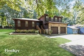 Atlanta house for rent - a brown house with a lawn and a garage