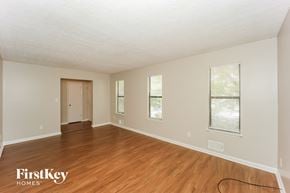 Atlanta house for rent - a spacious living room with wood floors and white walls