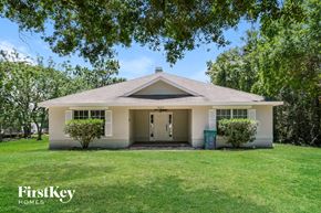 Saint Cloud house for rent - the front of a white house with a lawn and trees