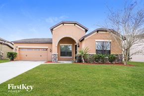 Kissimmee house for rent - a house with a driveway and a lawn