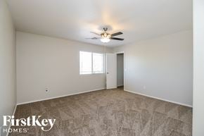 San Tan Valley house for rent - A spacious room with a carpeted floor and a ceiling fan.