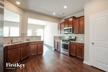 Mcdonough house for rent - a kitchen with wooden cabinets and stainless steel appliances