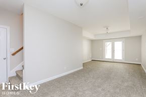 High Point house for rent - A spacious room with a carpeted floor and a door on the left side.