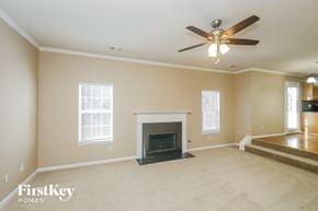 Douglasville house for rent - a living room with a fireplace and a ceiling fan