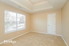 Douglasville house for rent - a bedroom with a large window and a white door