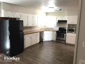 La Marque house for rent - A kitchen with white cabinets and a black fridge.