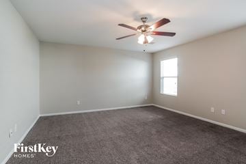 Katy house for rent - a living room with carpet and a ceiling fan