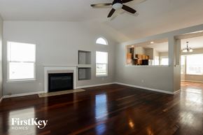 Indianapolis house for rent - A spacious living room with a fireplace and a fan.