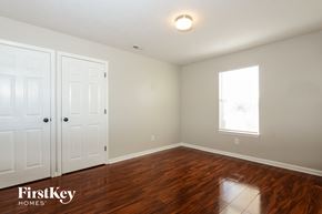 Indianapolis house for rent - A room with wooden floors and a window with a view of a building outside.