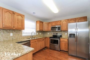 Winston-Salem house for rent - a kitchen with wooden cabinets and stainless steel appliances