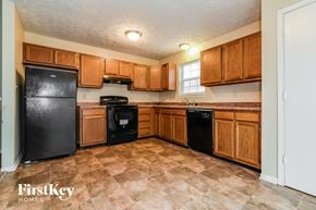 Indianapolis house for rent - a kitchen with black appliances and wooden cabinets