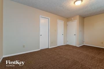 Indianapolis house for rent - the living room of an apartment with carpet and two doors