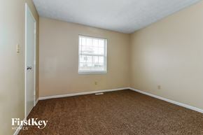 Indianapolis house for rent - a bedroom with a carpeted floor and a window