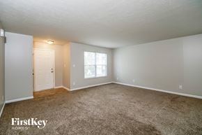 Indianapolis house for rent - A spacious room with a carpeted floor and a window letting in natural light.