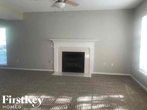 Charlotte house for rent - A room with a fireplace and a fan on the ceiling.