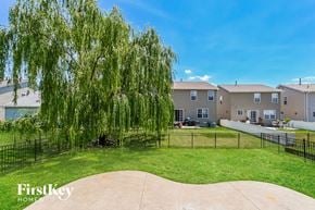 Saint Charles house for rent - a backyard with a weeping willow tree and some apartment buildings