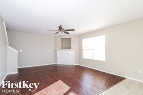 Winston-Salem house for rent - A spacious room with a ceiling fan and wooden flooring.