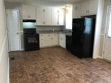 Dacula house for rent - A kitchen with black appliances and brown tiled flooring.