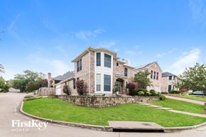 Rockwall house for rent - A house with a stone wall and a grassy front yard.