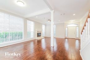 Rockwall house for rent - A spacious room with wooden floors and white walls.
