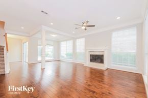Rockwall house for rent - A spacious living room with wood flooring and a fireplace.