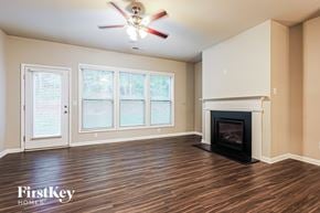 Mcdonough house for rent - A room with a fireplace and a ceiling fan.