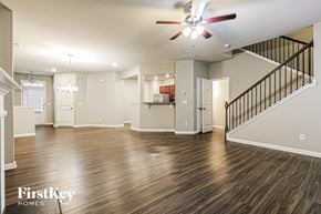 Mcdonough house for rent - A spacious living room with a staircase leading to the upper floor.