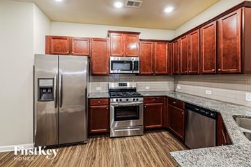 Mcdonough house for rent - A kitchen with wooden cabinets and stainless steel appliances.