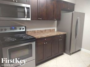 Fort Lauderdale house for rent - a kitchen with stainless steel appliances and wooden cabinets