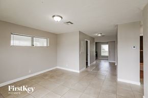 Lauderhill house for rent - A spacious room with a tile floor and a window with blinds.