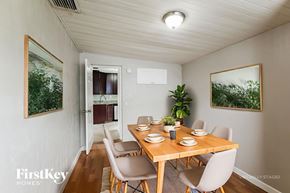 Lauderhill house for rent - A dining room with a wooden table and chairs.
