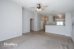 Queen Creek house for rent - an empty living room with a ceiling fan and a kitchen