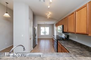 Queen Creek house for rent - a kitchen with granite countertops and wooden cabinets and stainless steel appliances