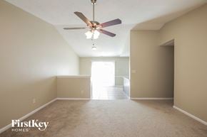 Monroe house for rent - A spacious room with a ceiling fan and carpeted floor.