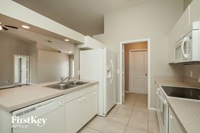 Lehigh Acres house for rent - a kitchen with white cabinets and a sink and a refrigerator