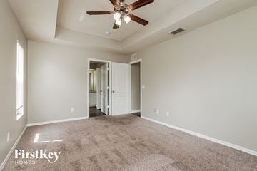 Lehigh Acres house for rent - a spacious living room with carpet and a ceiling fan