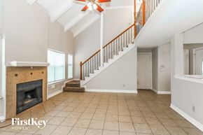 Humble house for rent - an empty living room with a fireplace and a staircase