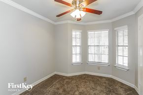 Humble house for rent - a living room with a ceiling fan and three windows