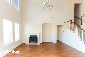 Mansfield house for rent - A large, empty room with a fireplace and wooden floors.
