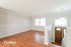 Mchenry house for rent - an empty living room with wood floors and white walls