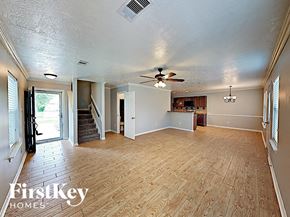 Pinehurst house for rent - an empty living room with wood floors and a ceiling fan