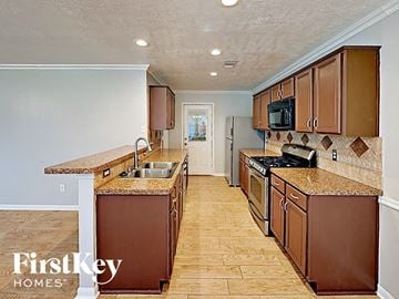 Pinehurst house for rent - a kitchen with wooden cabinets and granite counter tops