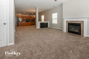 Charlotte house for rent - a living room with a fireplace and a carpeted floor