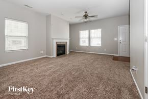 Charlotte house for rent - a living room with a carpeted floor and a fireplace