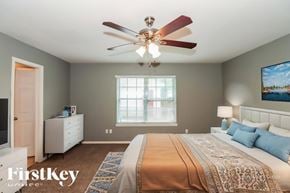 Missouri City house for rent - A bedroom with a large bed and a ceiling fan.