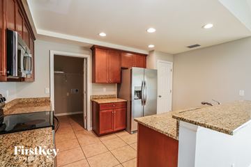 Cape Coral house for rent - a kitchen with granite counter tops and stainless steel refrigerator