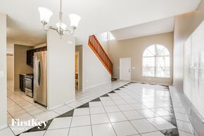 Sunrise house for rent - an empty kitchen and living room with a staircase and a window